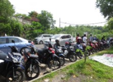Bikes and cars lined up along the road